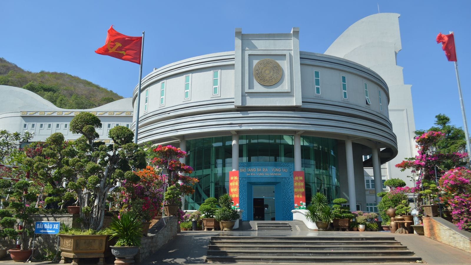 The Ba Ria-Vung Tau museum, a white drum of a building with a bronze Dong Son drum set into the front and flags flying either side of the steps