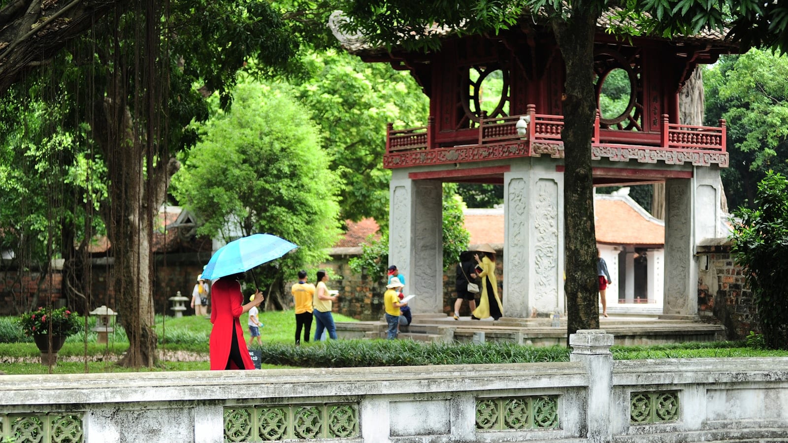 The gate pavilion at the Temple of Literature, a visitor in red walking past below