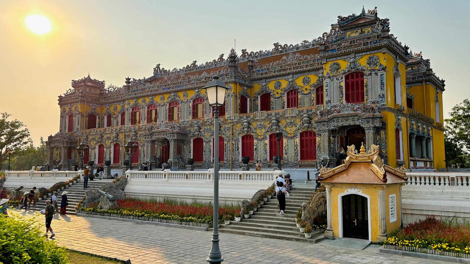 An ornate yellow and red palace facade in the Hue citadel in late light